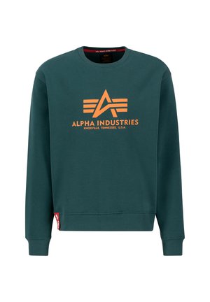 Groene sweatshirt met een oranje logo "ALPHA INDUSTRIES" en drie horizontale strepen, geribbelde manchetten en een klein rood label aan de zoom.