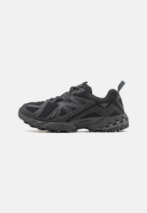 Black athletic shoe with mesh upper, rubber sole, and textured accents. Features a lacing system and pull tab for easy wear.