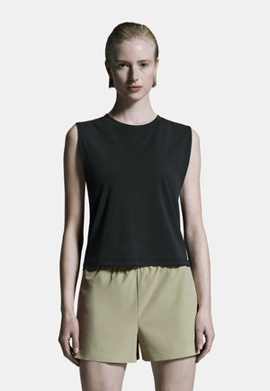 Schwarzes ärmelloses Oberteil mit rundem Ausschnitt, kombiniert mit hellen khakifarbenen High-Waist-Shorts. Glattes Material mit lockerem Schnitt.