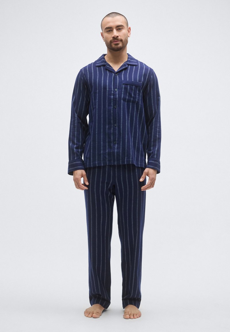 Granatowy, pasiasty zestaw piżamowy wykonany z miękkiej tkaniny, składający się z koszuli na guziki z kieszonką oraz pasujących spodni z gumką w pasie.