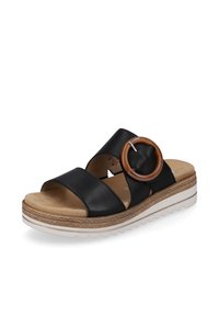 Black leather sandal with two wide straps, featuring a large circular brown accent, textured sole, and a platform base with a white stripe.