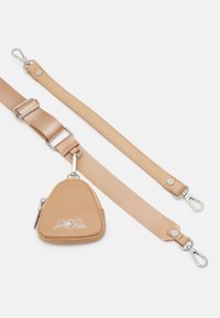 Beige triangulär påse med dragkedja, prydd med silverdetaljer och vingmotiv. Fäst vid ett avtagbart beigt rem med klipp.