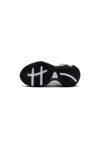 Suela de zapato atlético en blanco y negro con patrón de goma texturizada, con acentos blancos y elementos de agarre moldeados para tracción.