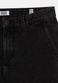 Svarta denimjeans med en slät textur, med knappstängning och bältesslingor. Etiketten visar storlek 152, varumärket "Jack & Jones."