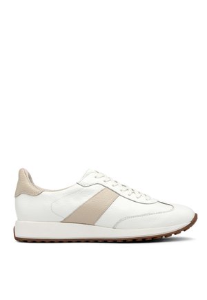Fehér bőr sneaker bézs akcentusokkal, sima textúrával, fűzős elejével és barna gumi talppal. Egyszerű dizájn csíkokkal.