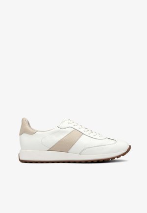 Fehér bőr sneaker bézs akcentusokkal, sima textúrával, fűzős elejével és barna gumi talppal. Egyszerű dizájn csíkokkal.