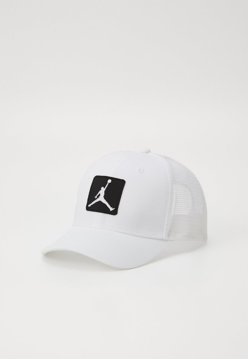 Hvit baseballcap med en svart rektangulær lapp som har en hvit silhuett av en hoppende idrettsutøver. Nettbakside for bedre pusteevne.