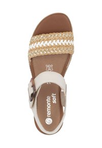 Beżowe sandały z plecioną cholewką z paskami w kolorze brązowym i białym. Płaska podeszwa z brązowym wkładem i akcentem w postaci klamry. Nazwa marki nadrukowana wewnątrz.