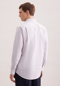 Camicia bianca con bottoni e strette righe verticali di colore viola chiaro, maniche lunghe e colletto classico, dotata di orlo arrotondato e polsini singoli.
