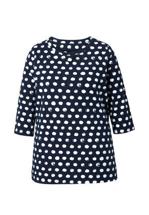 Marineblå langærmet skjorte med uregelmæssige hvide polkaprikker og en lille udskæring ved den runde hals.