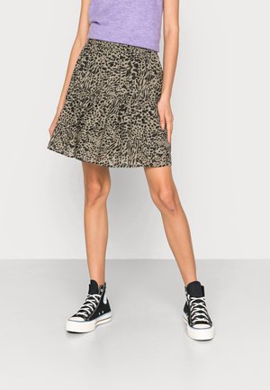 Jupe évasée à imprimé animal dans des tons terreux, avec un design à volants. Associée à des baskets montantes noires et un haut violet clair.
