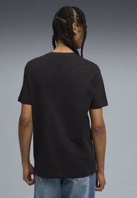 Black short-sleeve t-shirt made of cotton. Classic fit with a round neckline. Smooth texture, minimal design, no visible patterns or accents.