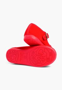 Clog-uri roșii din suede cu vârful rotund, curea ajustabilă la gleznă și talpă din cauciuc texturat cu modele florale și inimioare.