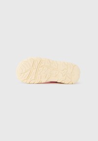 Μπεζ σόλα παπουτσιού με λεπτομερή σχεδιασμό πέλματος, εμφανίζεται από κάτω με λευκό φόντο.