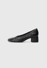 Black leather pump with a rounded toe and mid-block heel. Smooth texture with minimal detailing, featuring a subtle elastic opening.
