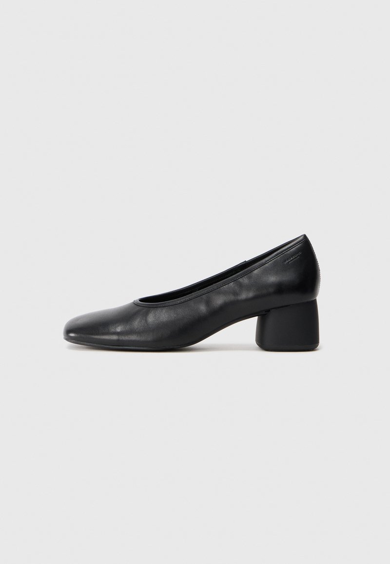 Black leather pump with a rounded toe and mid-block heel. Smooth texture with minimal detailing, featuring a subtle elastic opening.
