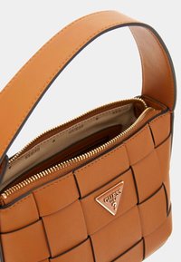 Borsa a tracolla in pelle intrecciata marrone con forma strutturata, cerniera dorata ed emblema metallico con marchio. L'interno è foderato e presenta una chiusura con zip.
