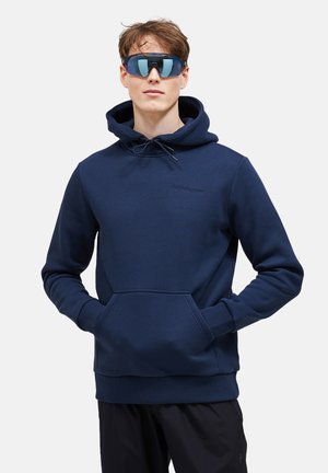 Granatowy hoodie z miękkiego materiału, z przednią kieszenią, kapturem na sznurki i haftowanym logo w tonacji. Połącz z czarnymi spodniami.