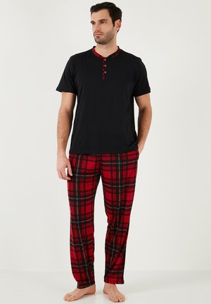 Sæt til herre, bestående af en sort T-shirt med korte ærmer og rødternet krave samt bukser i rødternet mønster, fremhævende et blødt bomuldsstof og en løs pasform.