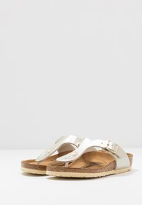 Metalliska krämsandaler i flip-flop stil med korkfotbädd, justerbar spännestraps, slät yta och gummisula.