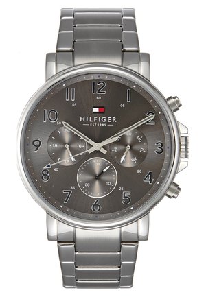 Silberne Tommy Hilfiger Armbanduhr aus Edelstahl mit grauem Zifferblatt, drei Hilfszifferblättern, arabischen Ziffern und Logo unter dem 12-Uhr-Markierer.