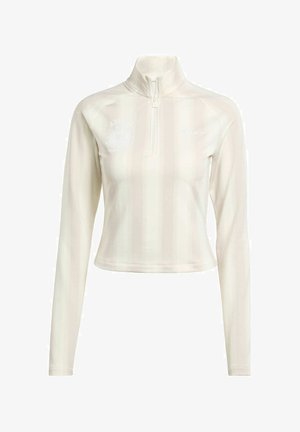 Biała, długorękawowa bluzka z zamkiem, z wysokim kołnierzem, z subtelnymi pionowymi paskami i akcentami logo na klatce piersiowej i rękawie. Miękka tekstura materiału.