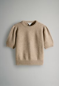 Beżowy krótki sweter z dzianiny z krótkim rękawem, z prążkowanym dekoltem, mankietami i dołem, pokazany na jednolitym szarym tle.