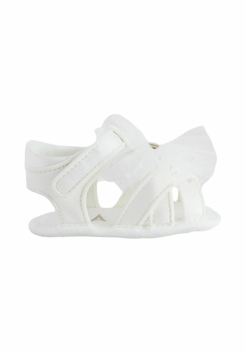 White baby sandals with a breathable design, featuring cutout details, textured fabric, and a decorative sheer bow on the side.