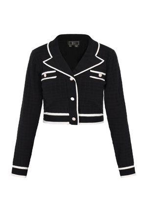 Cardigan noir court avec des accents blancs, présentant un col cranté, une fermeture à boutons à l'avant et deux poches poitrine avec des boutons décoratifs. Tissu texturé.