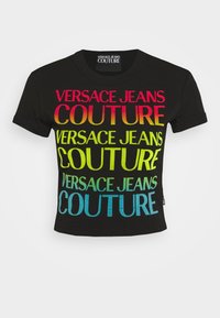 Svart kortärmad t-shirt med stor, mångfärgad text: "VERSACE JEANS COUTURE" i rosa, gult, grönt och blått gradient. Kort ärm.
