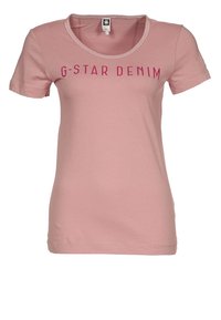 Růžové bavlněné tričko s krátkými rukávy, kulatým výstřihem a nápisem "G-STAR DENIM" vytištěným tučným fuchsiovým písmem na hrudi.