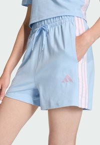 Svijetloplave atletske kratke hlače od mekog materijala, s elastičnim pojasom, vezicom i ružičastim trostrukim akcentima sa strane.