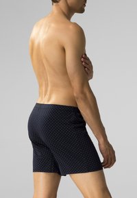 Granatowe szorty kąpielowe wykonane z lekkiego materiału, z subtelnym wzorem w diamenty, elastycznym pasem i dopasowanym krojem.