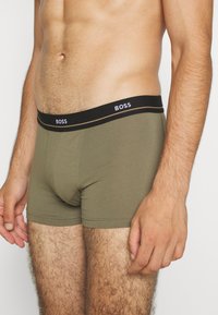 Boxers ajustados para hombres en una mezcla de algodón verde oliva, con una cinturilla elástica negra que lleva el logo de 'BOSS' y un ajuste ceñido.