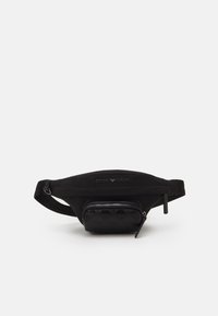 Mustassa lantiolaukussa on sileä kangas ja etupuolella vetoketjullinen tasku, jossa on logokuosi. Säädettävä olkahihna takaa tukevan istuvuuden.