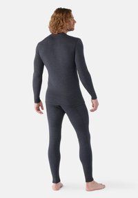 Herre termobase lag i mørkegrå. Langærmet top og tætsiddende bukser, lavet af blødt, struktureret materiale. Minimalistisk design, uden synlig branding.