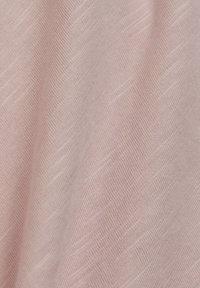 Tissu rose doux avec une fine texture côtelée diagonale et des plis doux créant des effets subtils de lumière et d'ombre.