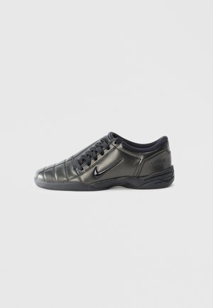 Black low-top Nike sneaker with laces, stitched detailing, and a textured sole against a plain white background.