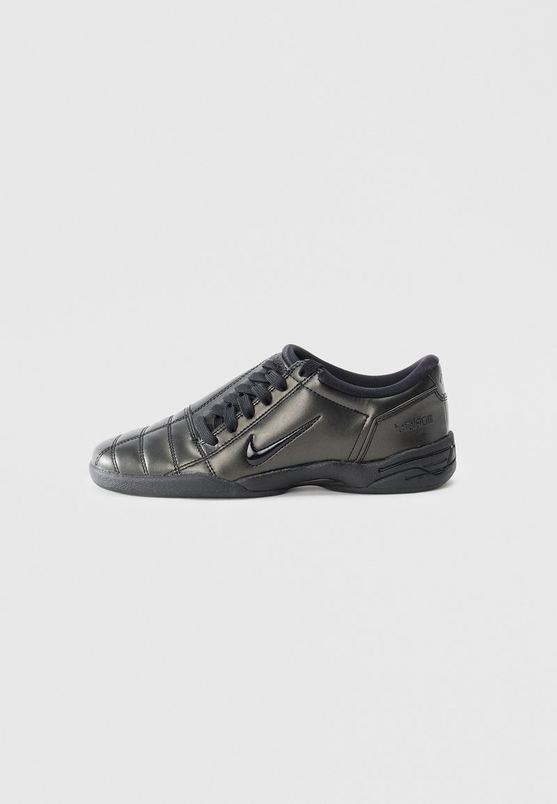 Black low-top Nike sneaker with laces, stitched detailing, and a textured sole against a plain white background.