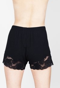 Zwarte katoenen shorts met een kanten zoom en bloemenpatronen. Elastische tailleband en een aansluitend ontwerp. Geschikt voor casual wear.