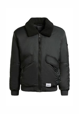 Jachetă bomber neagră cu guler pufos, fermoar în față și două buzunare laterale. Prezintă manșete și tiv cu model în valuri �și un patch cu logo pe partea inferioară.