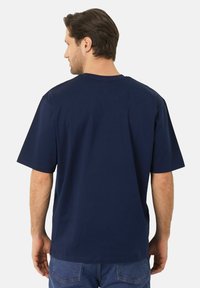 Námořnické bavlněné tričko s krátkými rukávy, kulatým výstřihem, volným střihem a minimálním prošitím na zadní straně. Jednoduchý design bez vzorů.