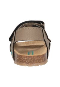 Brun sandal med et struktureret overdel, en justerbar rem og en korksål. Har et fladt design og en neutral farvepalet for alsidighed.