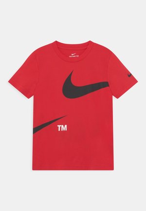T-shirt rouge Nike avec grands logos swoosh noirs et texte "TM" à l'avant, manches courtes et petit swoosh noir sur la manche gauche.