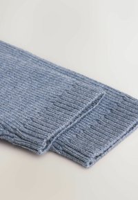 Knitted blue socks with a ribbed texture. Made of soft material, displaying a light to dark gradient pattern. Folded and layered design.