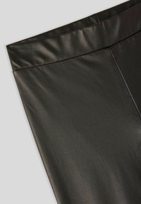 Czarne legginsy z sztucznej skóry o gładkiej fakturze, z szerokim, gładkim pasem w talii oraz zwężającym się krojem.