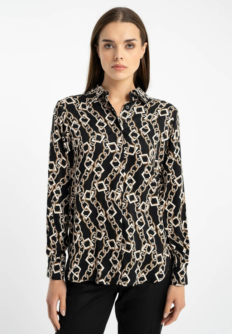 Czarna bluzka z wzorem łańcucha w kolorze złotym i białym. Długie rękawy i kołnierzyk. Gładki materiał z delikatnym połyskiem.
