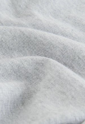 Lysegråt stof med en blød, struktureret overflade, der har subtile tonevariationer og et glat, draperet udseende.