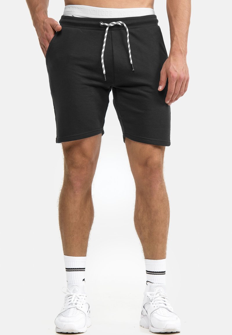 Schwarze Baumwollshorts mit einem weißen Kordelzug und einem mit Logo bedruckten Bund; verfügt über Seitentaschen und eine lockere Passform über den Knien.