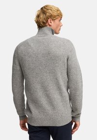 Maglione grigio a maglia con colletto alto, texture a coste e maniche lunghe, con retro dritto e vestibilità rilassata.
